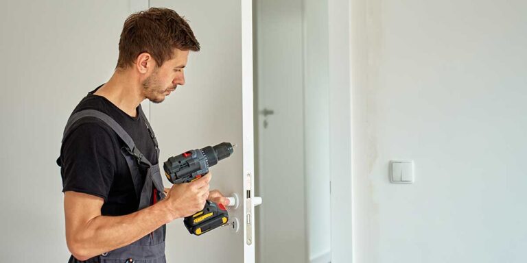 A professional installer uses a cordless drill to mount hardware, showcasing expert residential door installations services in Loganville, GA.